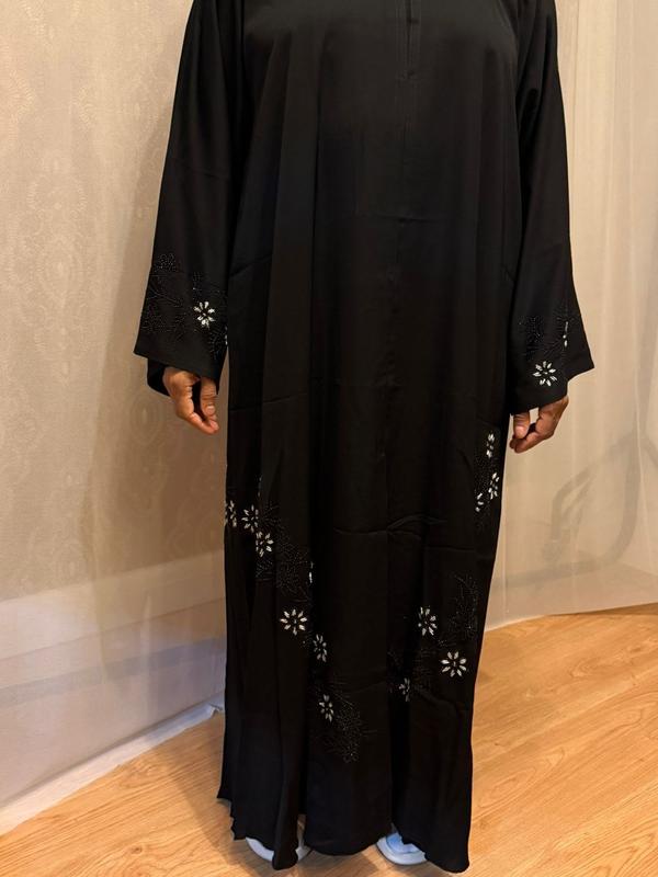The Hadiqa Abaya - a black satiny 'Dubai' Abaya with black and hand sewn silver bead work in a flower pattern pattern and includes a chiffon hijab. 0