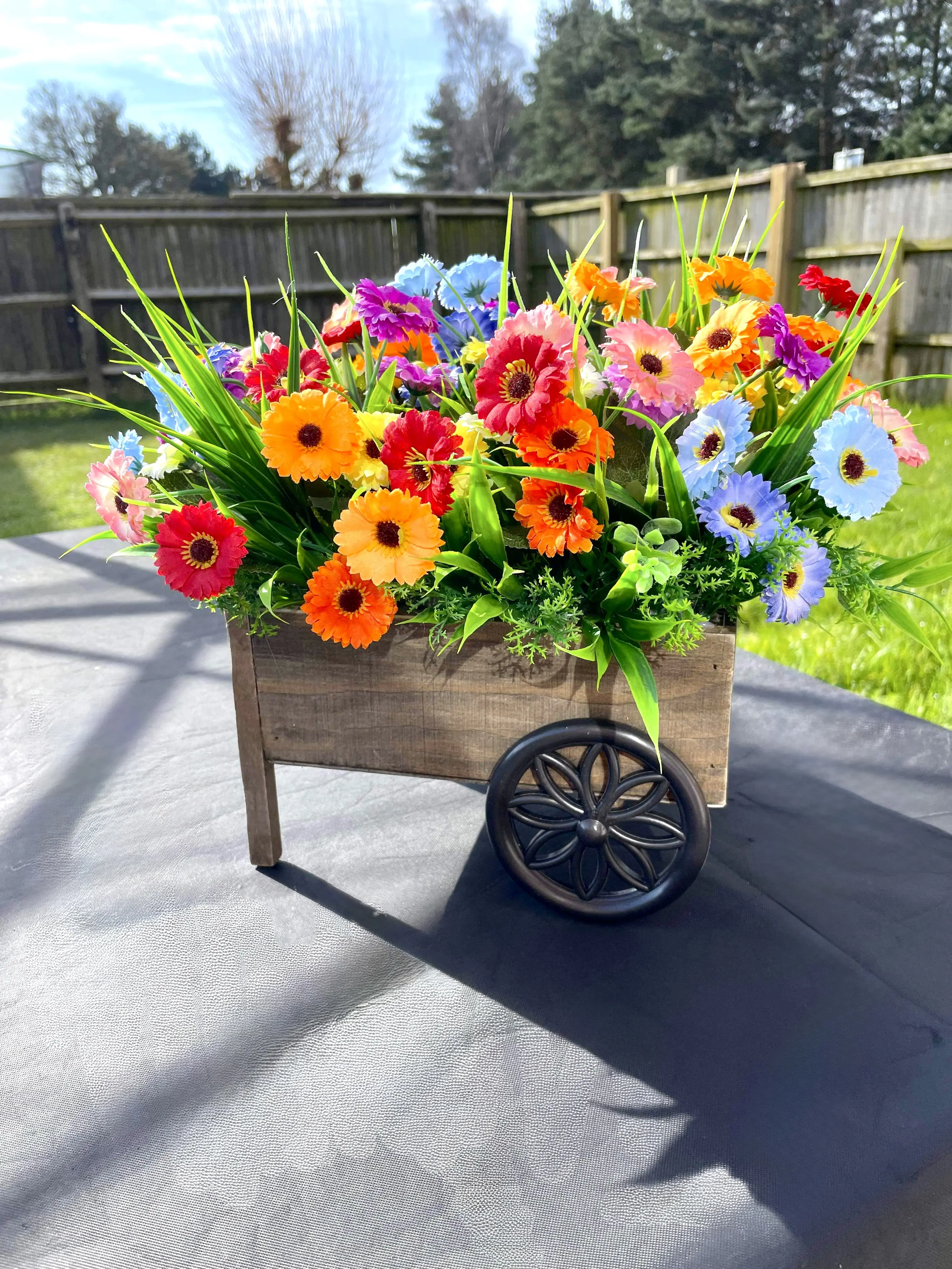 Esme’s Eternal Blooms wheel barrow planter filled with bright and colourful artifical flowers