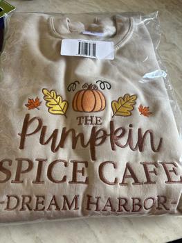 Product Review of The Pumpkin Spice Café Official Embroidered Crew Neck Sweatshirt - A warm beige super-soft sweatshirt with embroidered details (a collegiate style centre slogan, a pumpkin & autumn leaves). Boxy fit, crew neckline, cuffed sleeves and bottom hem. from A**c ** 0