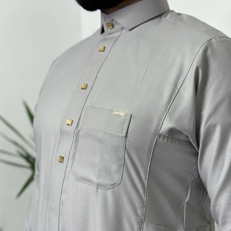 Grey Saudi Premium Thobe for Men - Indulgent Fabric, Breast Pocket & Two Side Pockets with yellow metal buttons.